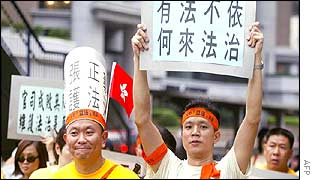 Civil servants march holding protest banners