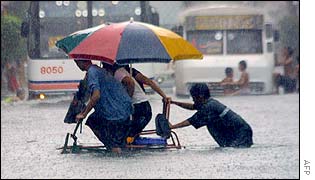 Residents cross a flooded Manila street