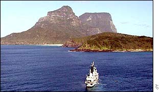 HMS Nottingham is held fast on rocks near Lord Howe Island, in background