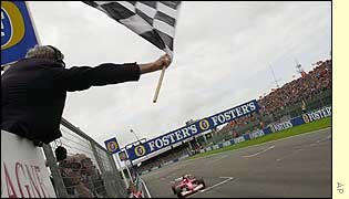 Michael Schumacher takes the chequered flag in the British Grand Prix