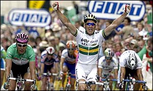McEwen lifts his arms arming crossing the finishing line