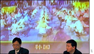Chinese officials play back a video of the alleged Falun Gong satellite interruption