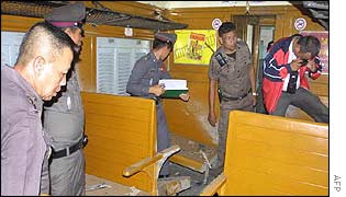 Police examine a train where a bomb was planted