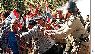 A policeman attacks a man during a protest in Ita