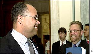 Federal Communication Commission chairman Michael Powell (left) talks to WorldCom chief executive John Sidgmore (right)  before testifying