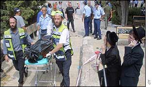 Two ultra-orthodox Jews look on as a victim is taken away from the scene of a bombing at a student cafeteria in Jerusalem