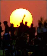 Sun and silhouetted figures   PA  
