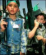 Palestinian children carrying toy guns