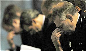 Police officers bow their heads in remembrance