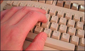 A mans hand on a computer keyboard