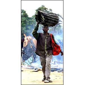 A man carrying sheets of corrugated iron  [picture: AP]