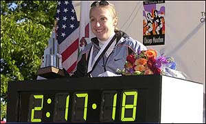 Radcliffe poses with the clock displaying her world record time