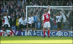 Dennis Bergkamp celebrates Steve Marlet's own goal in front of the ecstatic travelling Arsenal fans