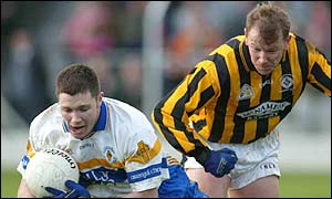 Enda McGinley of Errigal Ciaran goes down under the challenge of Martin Califf of Crossmaglen Rangers
