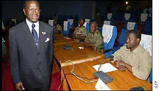 Ivory Coast government negotiator walks past rebels at talks