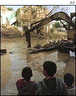 Children look at some of the devastation caused  by Operation Desert Fox