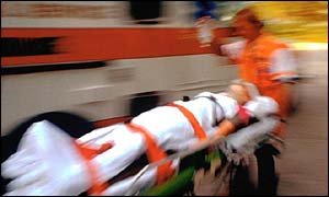 An ambulance worker moving a patient