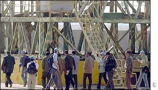 Inspectors look at a metal structure in a graphite rod factory in Amariyah, south-west of Baghdad