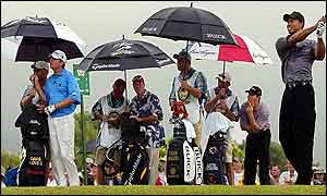 Tiger Woods plays his shot, watched by the other three players