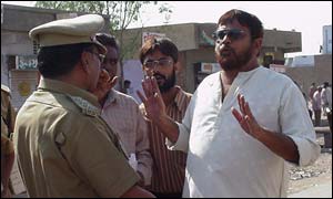 A voter argues with a police official at a polling station in Ahmedabad