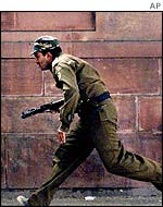 Policeman runs for cover outside Indian Parliament, 13 December, 2001