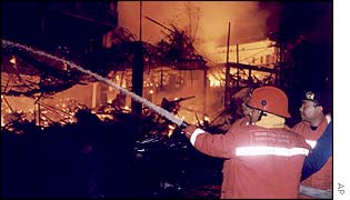 Firefighters attempt to extinguish the blaze ignited by a bomb blast at the Sari night club  on Kuta Beach, on the island of Bali, Indonesia, 13 Oct 2002