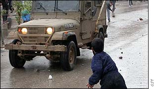 Palestinians attack an Israeli army jeep with stones in the West Bank town of Qalqiliya  on Thursday