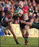 Paul Burke is tackled by two Leicester players