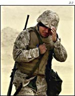 A US marine walks during a sand storm in the Kuwaiti desert on  Feb. 3, 2002 