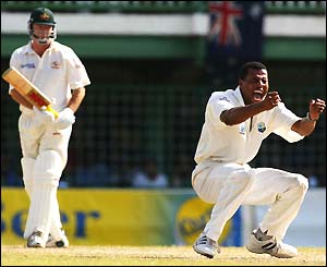 Steve Waugh of Australia starts to leave the pitch as Mervyn Dillon crouches on the ground celebrating his wicket