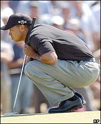 Tiger Woods lines up  a putt