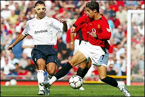 Man Utd's Cristiano Ronaldo  holds off Bolton's Youri Djorkaeff