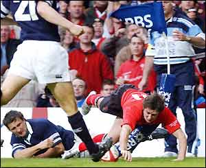 Wales' Shane Williams hits the corner flag as he touches down against Scotland