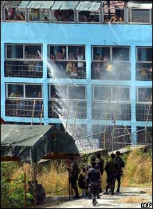 Detainees cheer as a fire truck sprays water on them to lessen the effect of tear gas  - 15/3/05