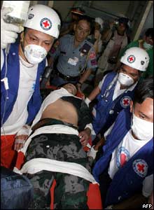Red Cross staff carry a wounded Filipino policeman  - 15/3/05