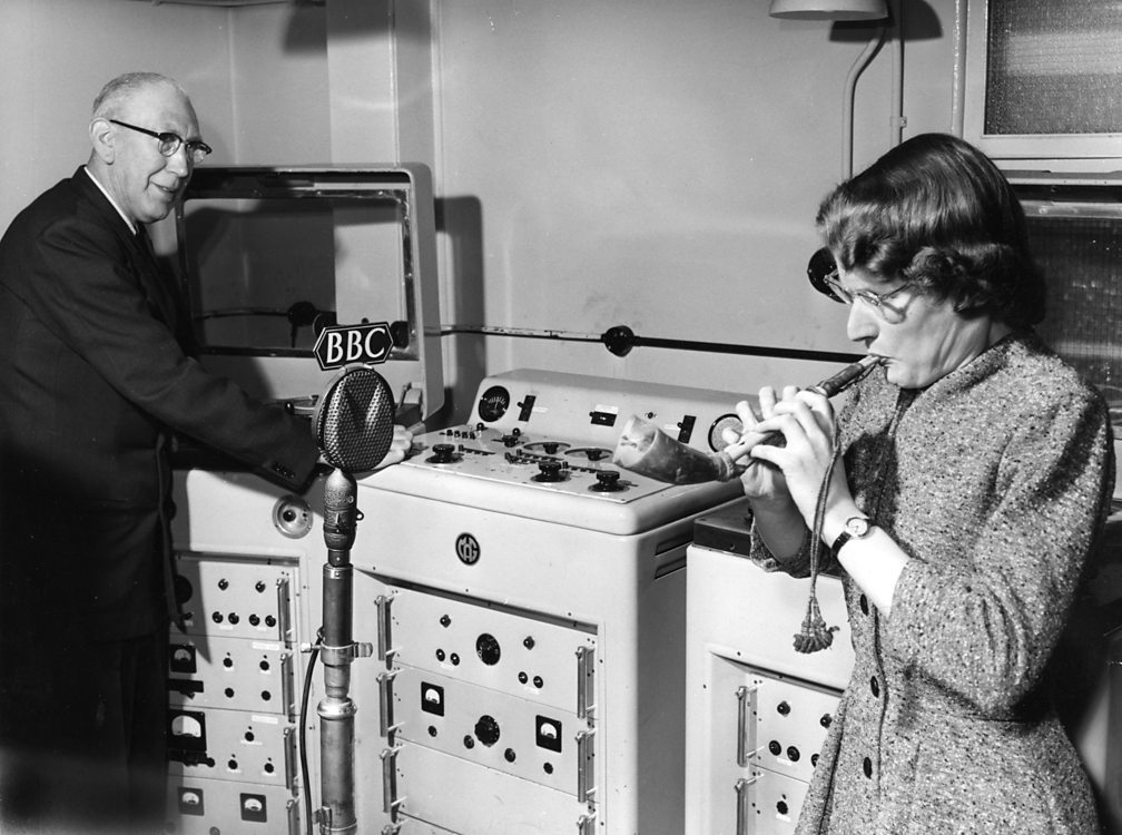 Daphne Oram in 1958 playing an Arabic reed pipe, while Radiophonic Workshop engineer Richard Bird records the sound on a tape machine