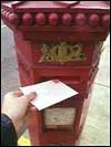 A letter being posted in an old fashioned postbox