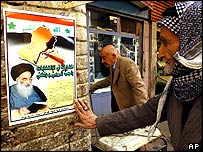 Şii lider Sistani'nin afişi ve bir Iraklı