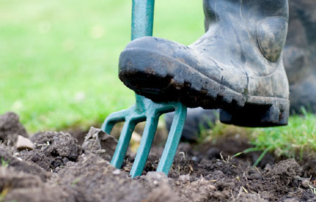 A person forking soil