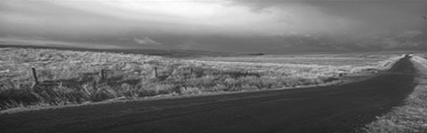 'In the darkness, between the fields, the road stretched into the distance.'  Photograph by Pascal Diamond.