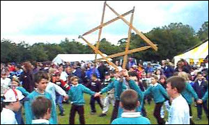 Children hold wooden star in the air.