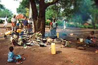 Relatives of patients making lunch under a tree in the waiting area