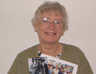 Philomena Cooper with photographs showing four generations of her family - her grandparents, two of her daughters and her grandson