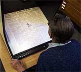 Image of Cliff Howe studying an old newspaper