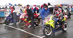 Riders in the rain get ready for the off at the NW200