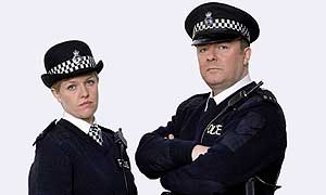Maggie Jacobs (Ashley Jenson) and Andy Millman (Ricky Gervais) are Extras