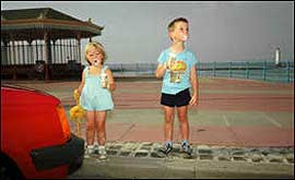 Little girl with ice cream next to little boy on front at New Brighton in the 1980s
