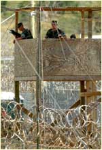 A photograph of two U. S. soldiers guarding Camp X-Ray.