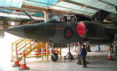 Two boys stand beneath the Buccaneer aircraft