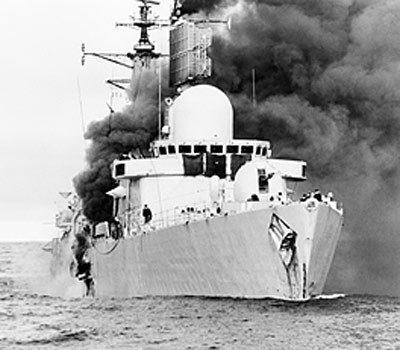 The destroyer HMS SHEFFIELD on fire after being struck by an AM39 Exocet missile fired by an Argentine aircraft